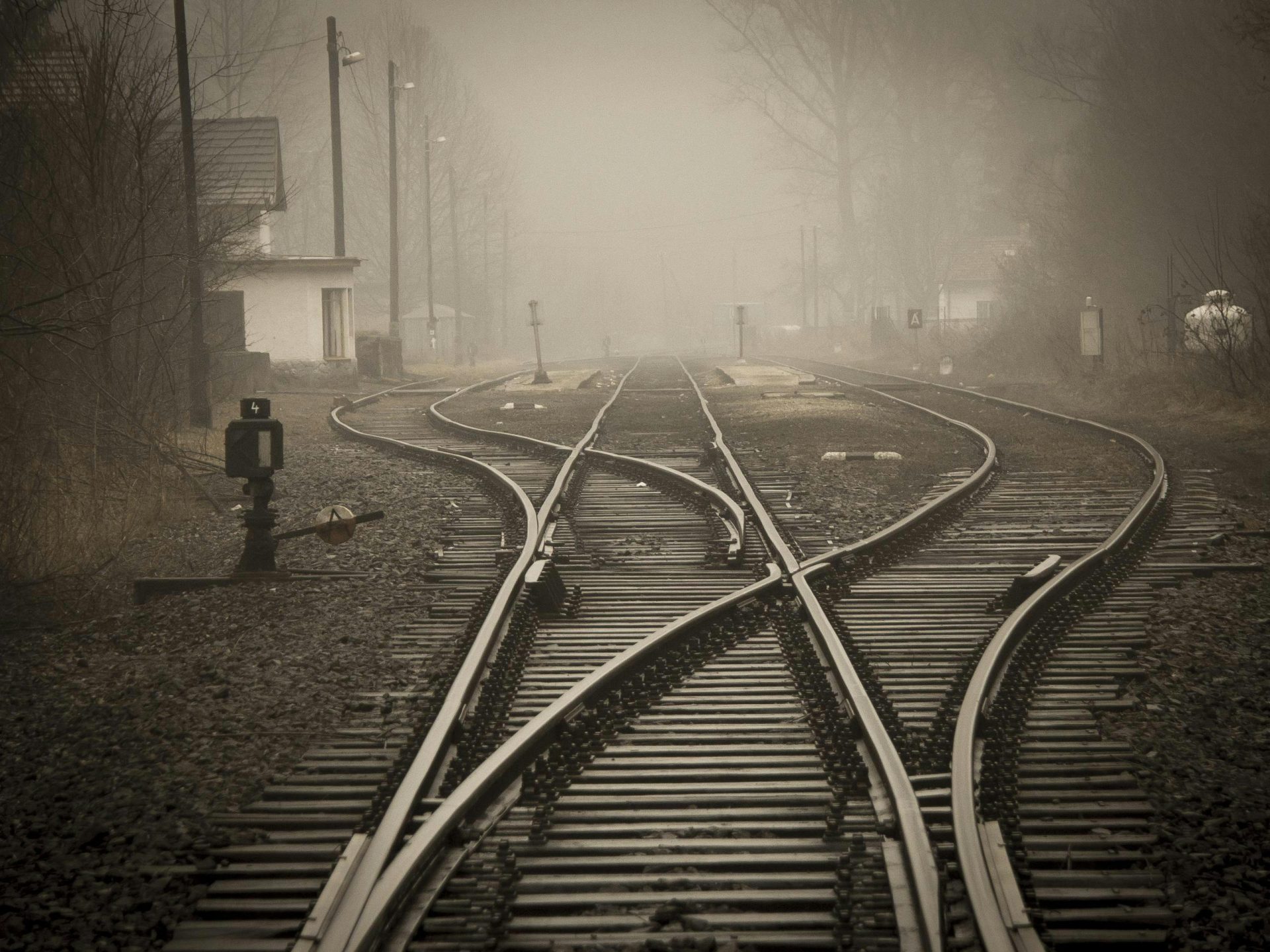 Moody foggy railway tracks in a misty landscape, evoking travel and mystery.