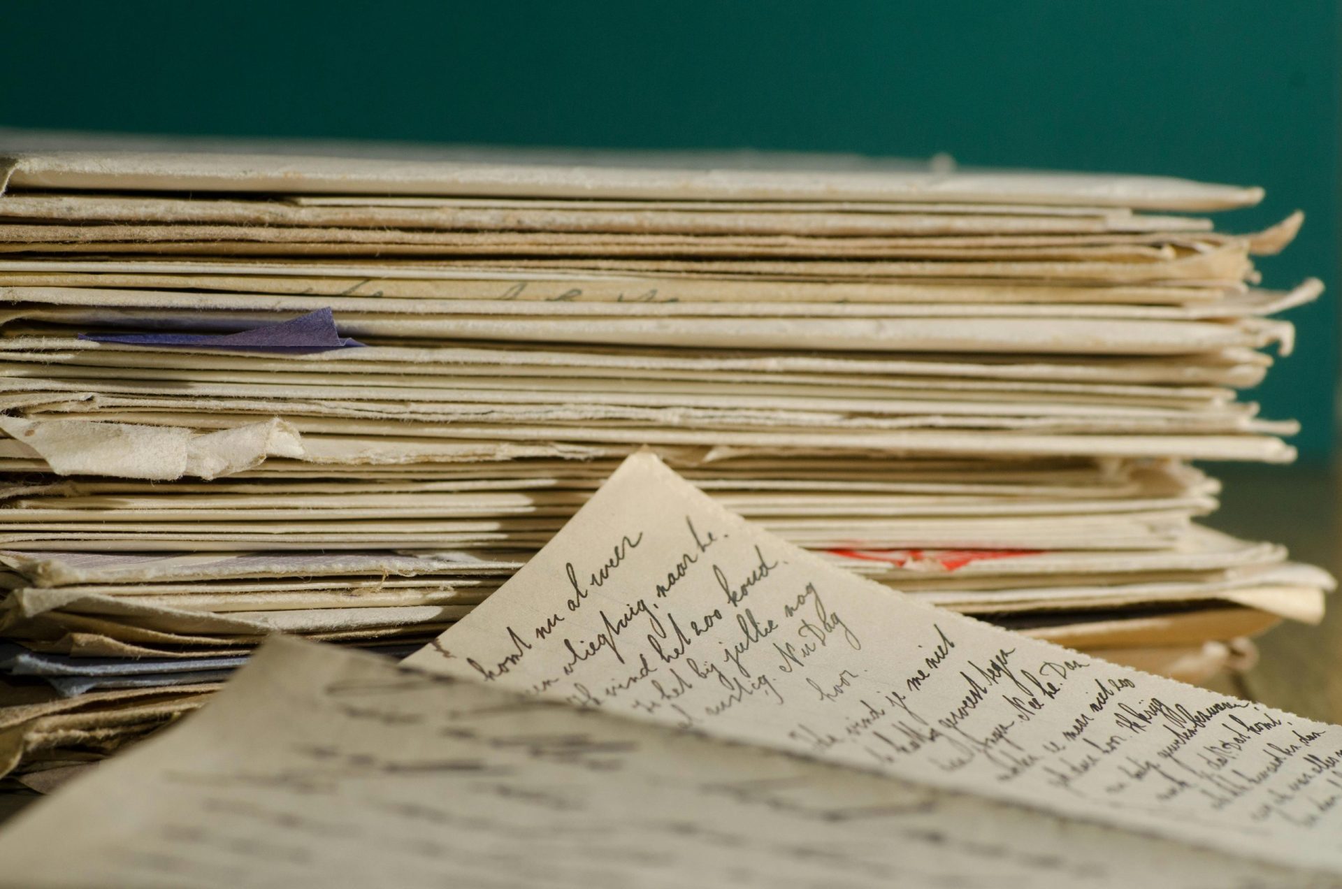 Close-up image of handwritten letters and papers stacked together, conveying a vintage feel.